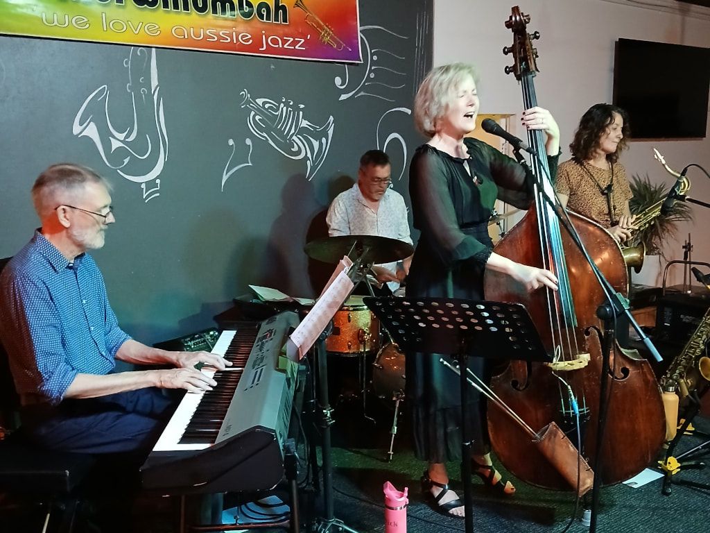 Nikki Parrott singing at the double bass, with Steve Russell on piano and Martha Baartz on sax