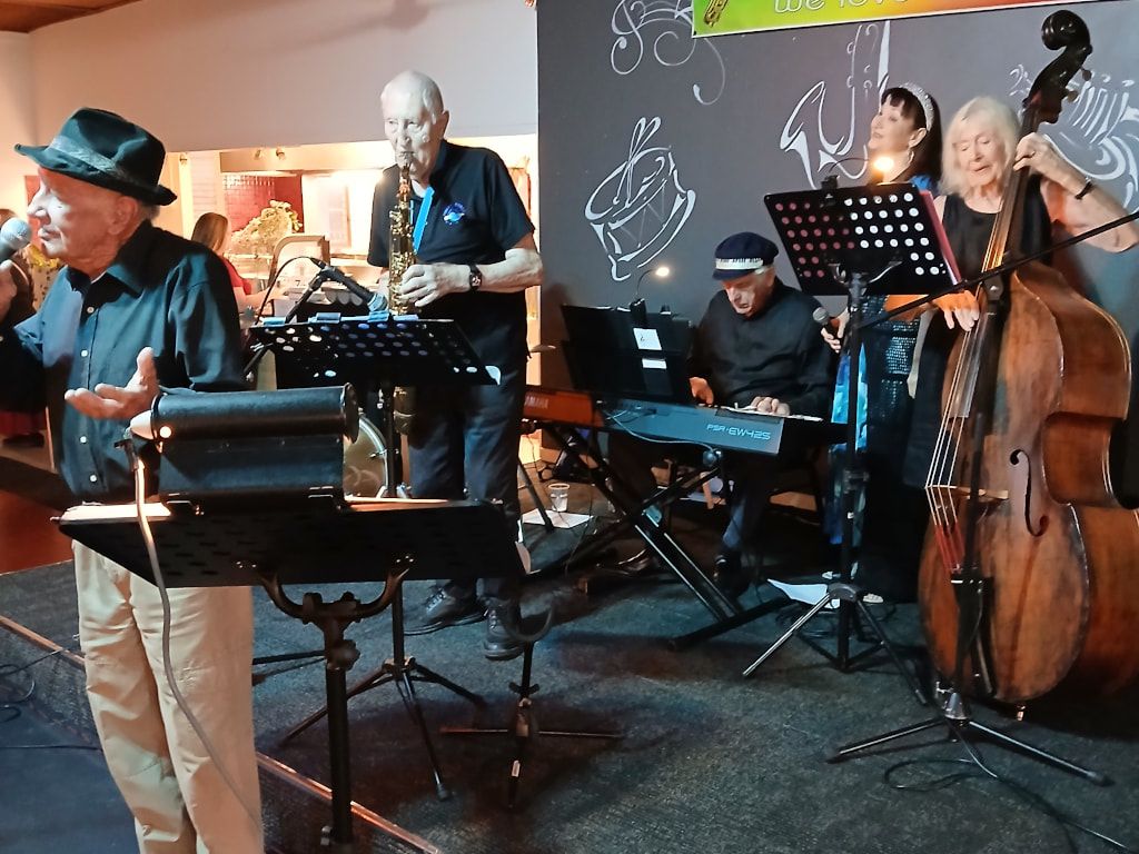 The Early Birds with a singer in a hat, sax, keyboard and double bass