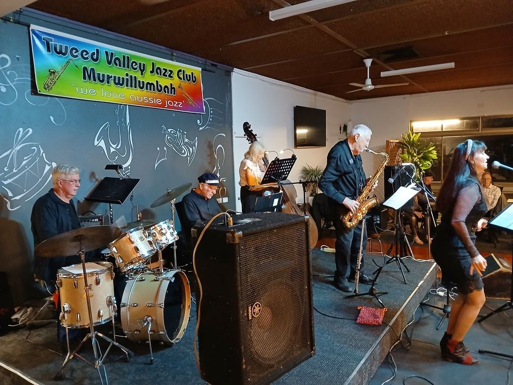The Early Birds with a saxophonist and a singer under the club banner
