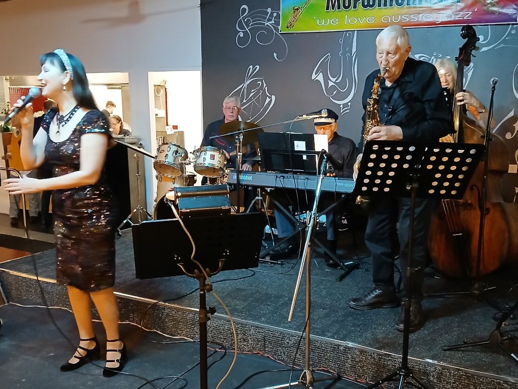 The Early Birds' singer Antonia Breen at the microphone, with a saxophonist